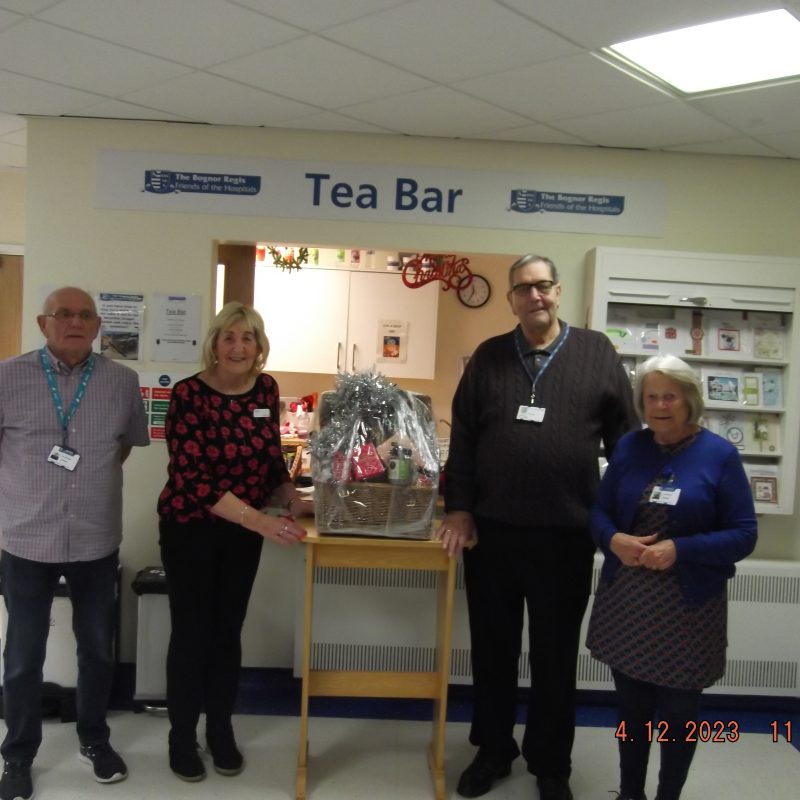 The Friends Chairman Brian Knight, with Friends June and Mick, in front of the Tea Bar with Jackie from M&S and a Christmas hamper prize