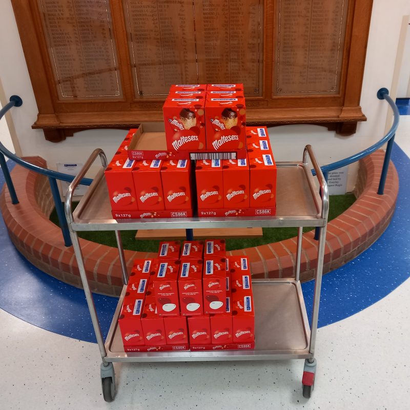 A trolley stacked with 48 red Maltesers easter eggs, pictured in front of the war memorial.