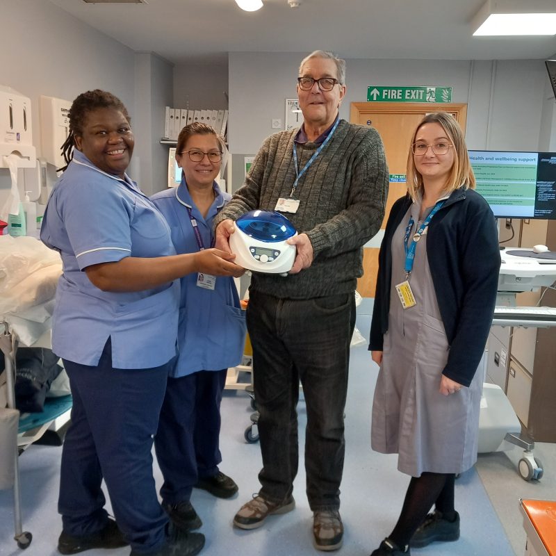 Chairman Brian Knight presents three team members from the Renal Unit with a centrifuge machine