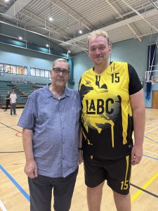 Friends Chairman Brian Knight MBE stands with Luke Attfield of LABC who is wearing a bright yellow and black basketball jersey