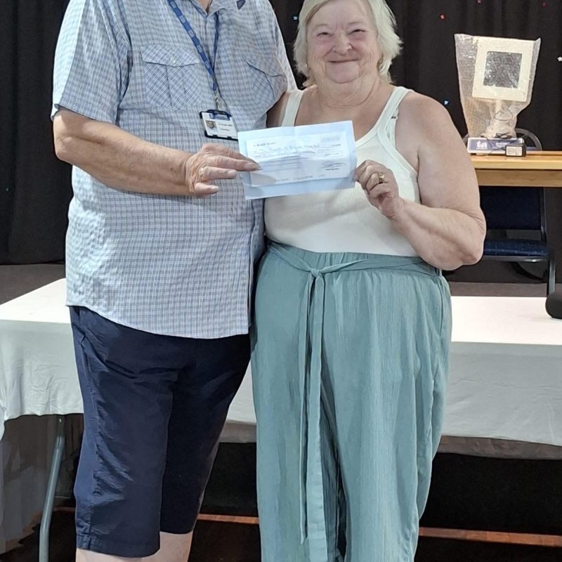Chairman Brian Knight receives a donation from Chairwoman of the League Angie Roberts