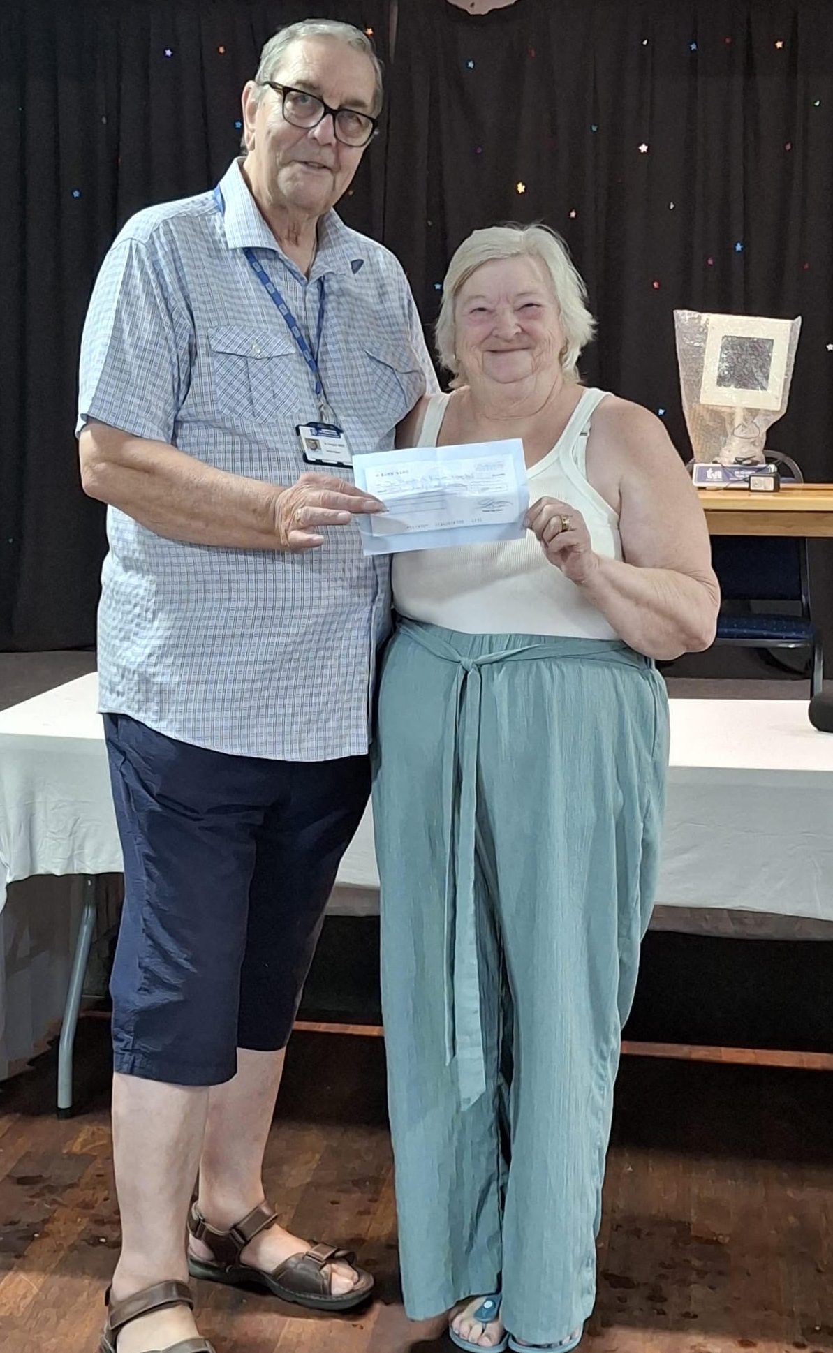 Chairman Brian Knight receives a donation from Chairwoman of the League Angie Roberts